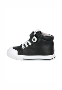 Zapatilla alta de cuero negro con puntera y suela de goma blanca, con cordones y una banda de Velcro, acentuada por un logotipo circular en la banda.