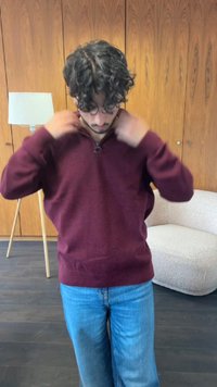 Bordeauxkleurige zip-up trui van textuurstof, met een staande kraag en lange mouwen, gecombineerd met lichtblauwe denim jeans.