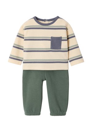 Beige and green toddler outfit with long-sleeve striped top featuring a front pocket and solid green elastic waistband pants.