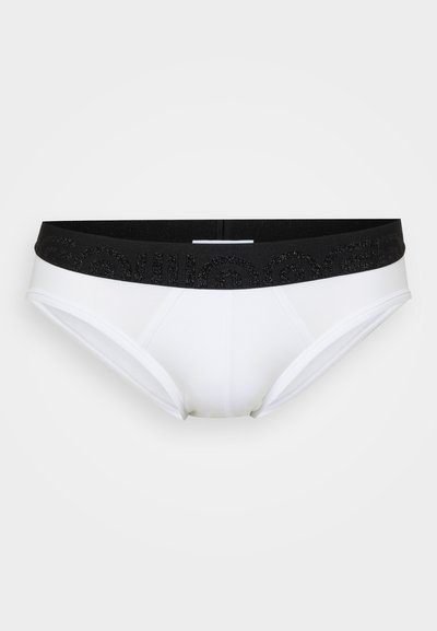 Hvide trusser med en sort elastisk taljeled, der har et tekstureret logomønster. Glat stof, mid-rise snit og sømløse sider.