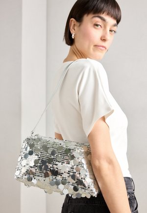 Silver sequin handbag with a rectangular shape, smooth texture, and a shoulder strap. Features circular reflective sequins arranged in patterns.