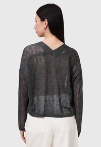 Dunkelgrauer, gestrickter Pullover mit V-Ausschnitt, lockerer Passform und transparenter Textur. Die Rückseite zeigt ein offenes Maschenmuster.