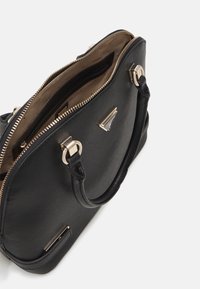 Schwarze, strukturierte Handtasche mit goldenen Hardware-Details. Verfügt über einen Reißverschluss, zwei Griffe und eine Öffnung, die Fächer im Inneren sichtbar macht.