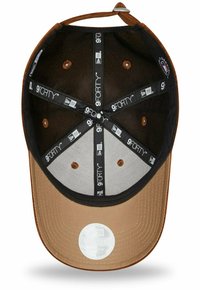 Braune Kappe mit einem schwarzen und grauen Innenfutter. Verfügt über Belüftungslöcher und ein Schweißband. Das Etikett liest "9FORTY" in Weiß auf der Innenseite.