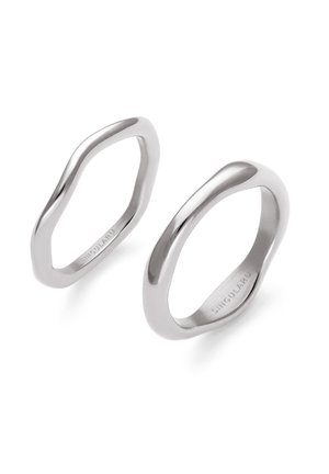 Two irregularly shaped polished silver rings with smooth surfaces and engraved brand name on inner bands, displayed on white background.