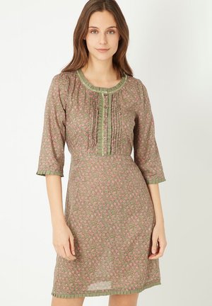 Vestido floral en verde con pequeñas flores rosas. Presenta un frente plisado, cierre de botones y mangas de 3/4 con puños rizados.
