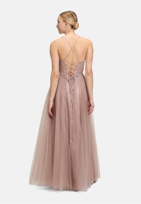 Długa sukienka wieczorowa w różowym odcieniu, z zawiązywaniem z tyłu, cienkimi ramiączkami i zwiewną spódnicą z tiulu o miękkiej fakturze i warstwowym kroju.