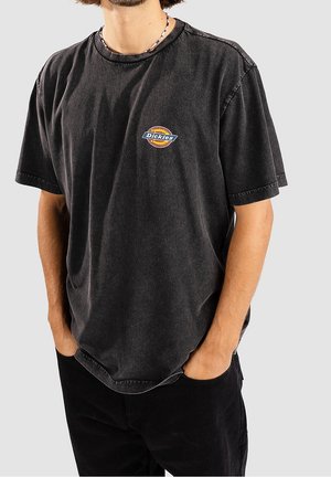 Czarna bawełniana koszulka z luźnym krojem, okrągłym dekoltem i krótkimi rękawami. Na przodzie znajduje się okrągłe logo „Dickies”.