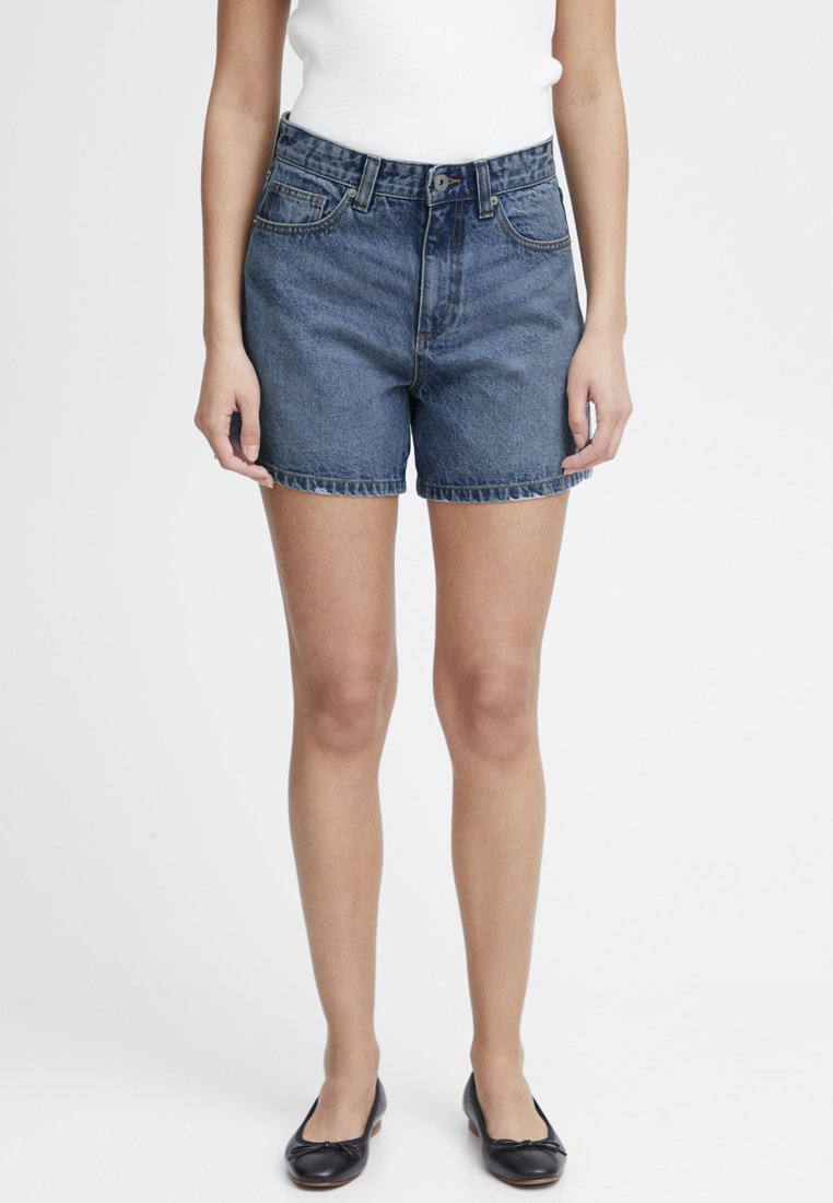 Shorts en denim bleu foncé, avec taille haute, un design classique à cinq poches et une coupe droite avec des ourlets retroussés.