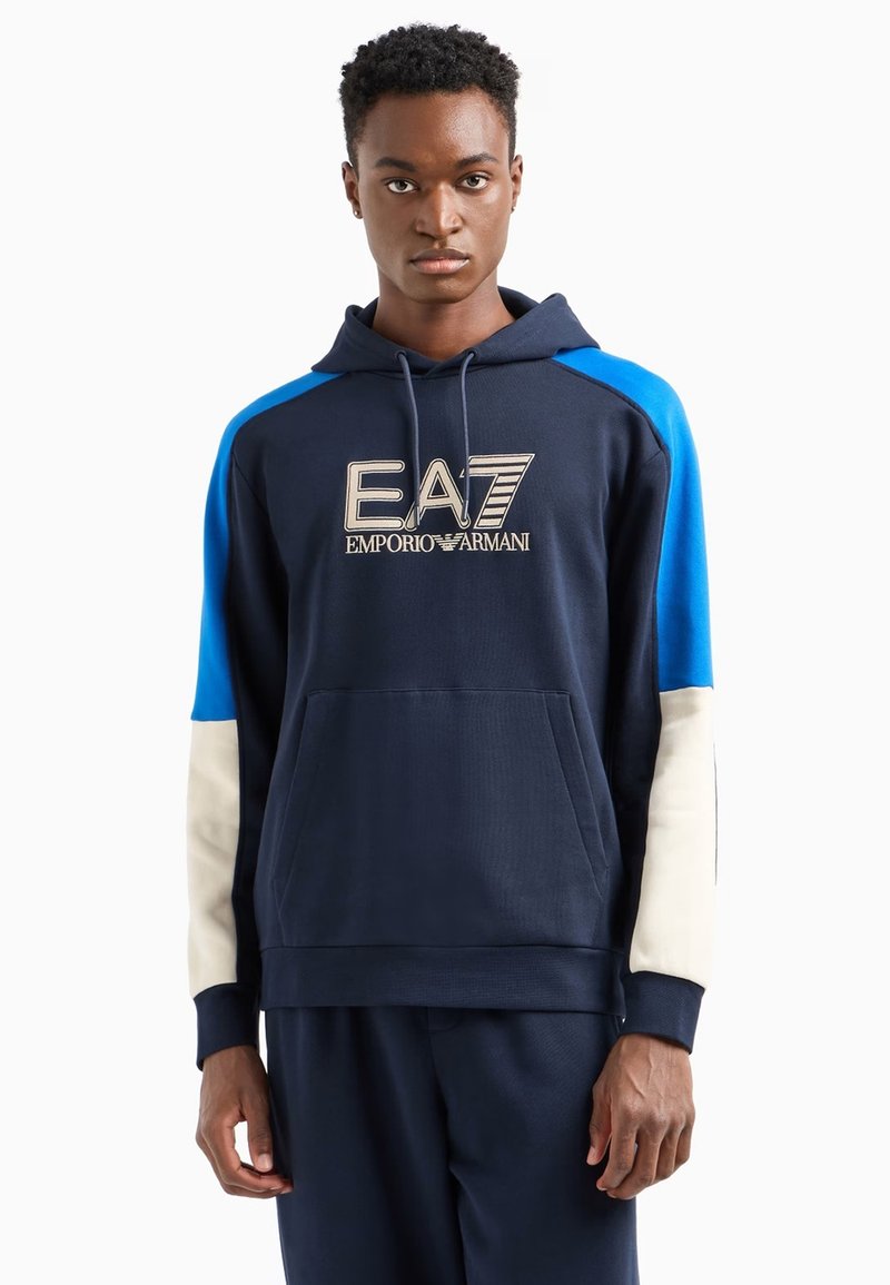 Sudadera con capucha azul marino con detalles en azul y crema, que cuenta con un bolsillo frontal y el logo bordado de EA7 Emporio Armani.