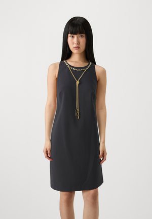 Abito senza maniche di un elegante grigio scuro con scollatura rotonda, caratterizzato da un'accentuata catena dorata che scende dal collo all'orlo. Tessuto liscio con un design minimalista.