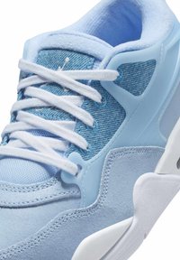 Blauer Sneaker mit Denim- und strukturiertem Wildledermaterial, weißen Schnürsenkeln und einem markanten Zwischensohlen-Design mit hellblauen Akzenten.