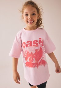 Vrhnjena roza majica z rdečim grafičnim tiskom z besedo "oasis" in podobo, ki spominja na prizor. Kratki rokavi in okrogli izrez.