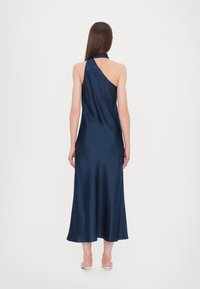 Marineblå satinkjole med ét skulderdesign og en svajende nederdel. Stoffet har en glat tekstur og en let glans. Længden går til midt på læggen.