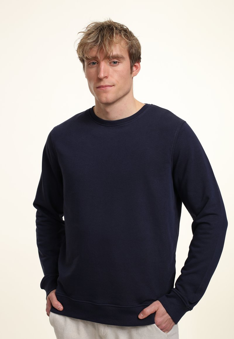 Felpa blu navy realizzata in tessuto morbido, dotata di un classico scollo rotondo e maniche lunghe con polsini a coste, vestibilità rilassata.