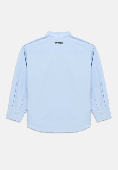 Ανοιχτό μπλε πουκάμισο μακρυμάνικο με γιακά τύπου spread, μανσέτες με κουμπιά και ένα διακριτικό λογότυπο Moschino κεντημένο στο πίσω μέρος. Λείο βαμβακερό ύφασμα.