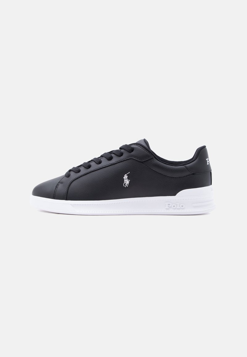 Baskets basses en cuir noir avec semelle blanche, logo Polo blanc sur le côté et lacets noirs sur fond clair uni.