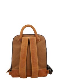 Mochila de lona marrón con detalles de cuero marrón claro, que cuenta con un asa superior y correas ajustables. Cierre con cremallera y detalles de costura en contraste.