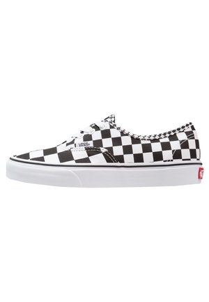 Baskets basses Vans à carreaux noir et blanc avec semelle blanche en caoutchouc et lacets, vues de profil sur fond blanc.