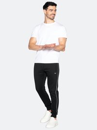Witte katoenen t-shirt en zwarte trainingsbroek met zijstrepen, gecombineerd met witte sneakers. Heeft een koordmatige taille en een slim fit.