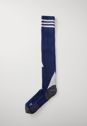 Chaussette de compression bleu marine avec des rayures blanches en haut. Présente des motifs en tricot texturé et une zone grise au talon et aux orteils.