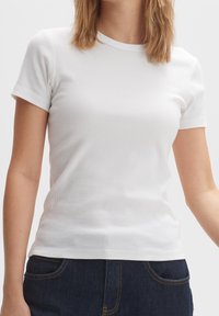 T-shirt bianco a maniche corte con scollatura rotonda e design aderente, realizzato in morbido cotone.