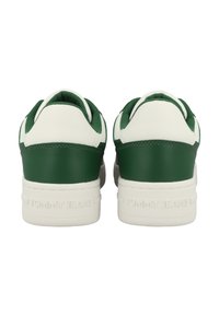 Zapatillas verdes y blancas con un upper de cuero liso y textil, que cuentan con una suela de goma texturizada y un logotipo en relieve en el talón.