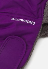 Ljubičasta tkanina s Didriksons logom izvezenim u bijelo, s preklopom koji je prošiven i s dijelom sivog flisa koji je vidljiv.