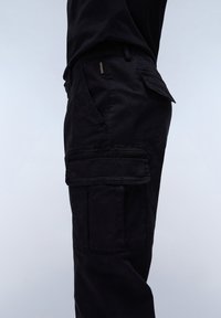 Black cargo pants featuring multiple pockets, a slim fit, and made from a lightweight fabric with a smooth texture.