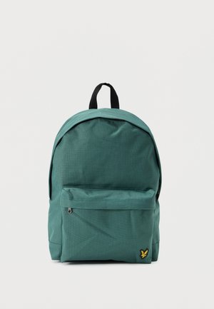 Sac à dos en tissu vert avec poignée noire, poche avant à fermeture éclair, et petit logo d'oiseau jaune dans le coin inférieur sur un fond uni.