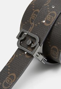 Cintura in pelle marrone a motivo con una fibbia in metallo nero lucido dotata di meccanismo a gancio, evidenziando una superficie testurizzata e dettagli del logo.