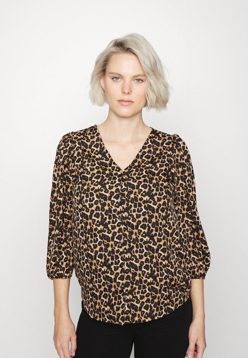 Blusa com estampado de leopardo, decote em V, mangas 3/4 e corte solto. Feita de tecido leve com uma textura suave e botões pretos.