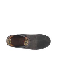 Scarpa slip-on in pelle nera con punta arrotondata, superficie testurizzata, accenti laterali elasticizzati e una fodera interna marrone con etichette del logo.