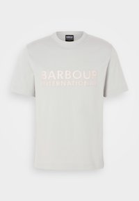 Svetle šedé tričko vyrobené z bavlny, s krátkými rukávy a kulatým výstřihem. "BARBOUR INTERNATIONAL" je výrazně vyšíváno v jemně růžové barvě.