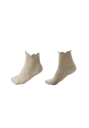 Paar beige Knöchelsocken mit gerippter Textur und wellenförmigen elastischen Bündchen auf weißem Hintergrund dargestellt.