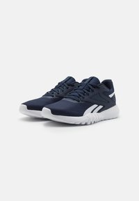 Baskets de sport navy avec une tige en maille texturée, accents blancs, système de laçage et semelle en caoutchouc flexible dotée d'un profil antidérapant.