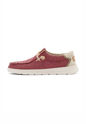 Zapato informal tipo slip-on con tejido rojo texturizado, acentos beige, detalles de cordones de cuerda y suela de goma blanca, mostrado en perfil lateral.