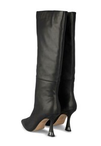 Botas de cuero negro hasta la rodilla con punteras afiladas y tacones de aguja brillantes. Textura suave y detalles en las costuras en la pantorrilla.