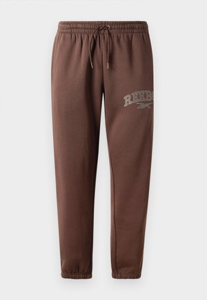 Brown sweatpants featuring an elastic waist with drawstring, tapered cut, and a "REEBOK" logo in gray on the left leg. Smooth fabric texture.