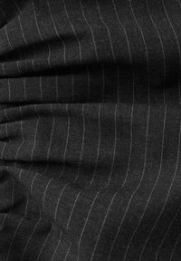 Tissu noir avec de fines rayures grises, présentant une surface texturée et un plissage subtil, créant de la profondeur et du mouvement.