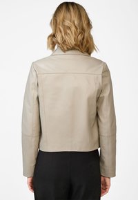 Beige leren jas met kraag, aangesloten ontwerp en lange mouwen. Glad textuur en een verkorte lengte, met een eenvoudige, schone achterkant.