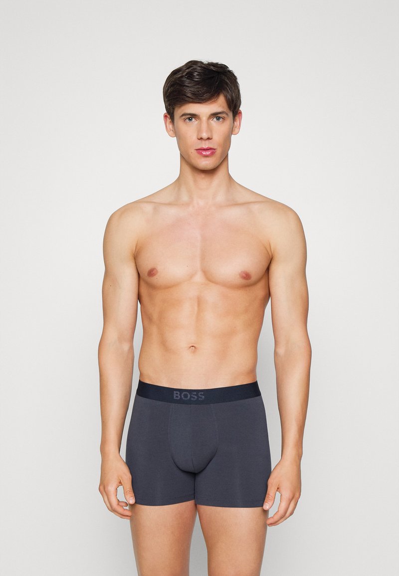 Boxer briefs cinza escuro com uma faixa elástica rotulada "BOSS", apresentando um design ajustado e textura suave.