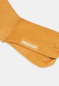 Oranje geribde sokken van zacht materiaal, met een wit DillySocks-logo. Het ontwerp is soepel met een comfortabele pasvorm.
