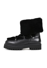 Botas de cuero negro con un puño de tela esponjosa, puntera redondeada y suela gruesa y resistente. Presentan una parte delantera con cordones y detalles metálicos.