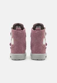 Ψηλές αθλητικές μπότες από βελούδινο ροζ σουέτ με υφή, λευκές λεπτομέρειες και γκρι ελαστικές σόλες. Διαθέτουν ρυθμιζόμενους ιμάντες στα πλάγια.