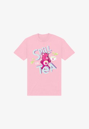 Camiseta de algodón rosa con un gráfico de un oso rosa sosteniendo una taza de té. El texto dice "Spill the Tea" en colores azul y verde.