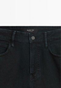 Jeans in denim neri con vita standard, chiusura con bottone in metallo e classico design a cinque tasche. L'etichetta riporta "Massimo Dutti."