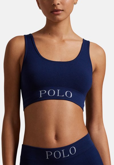 Námořnicky modrý žeberný bralette s širokým páskem s logem "POLO." Má kulatý výstřih a nastavitelná ramínka pro pohodlí.
