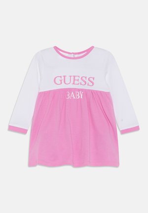 Witte en roze babyjurk met lange mouwen, met een geplooide roze rok, een witte bovenkant en de tekst "GUESS BABY" geborduurd op de voorkant.