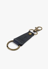 Llave de cuero en negro con herrajes de latón, que cuenta con un anillo de llave redondo y un mosquetón. Textura suave con detalle de logotipo en relieve.